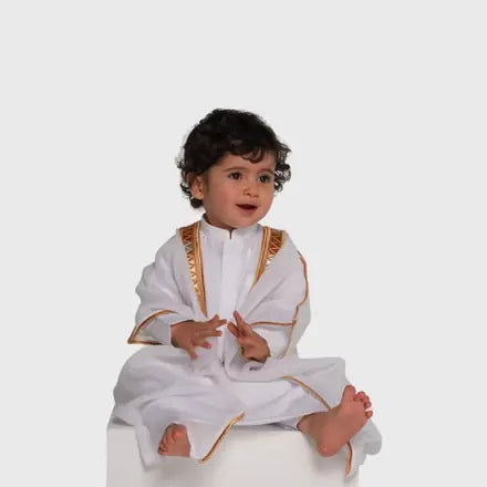 Toddler in a white bisht with gold trim